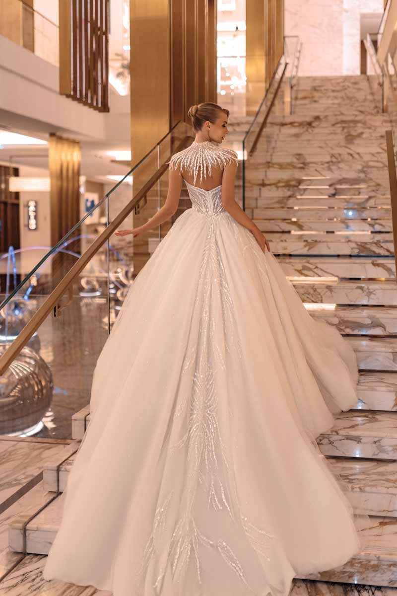 Abito da sposa Giovanna Alessandro modello Alora con gonna ampia ricamata su una scalinata di marmo
