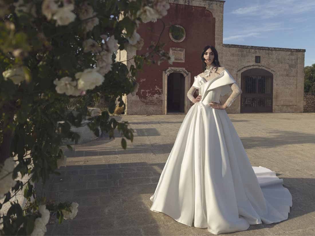 Abito da sposa Pietro De Mita in mikado con gonna ampia nel cortile di una masseria
