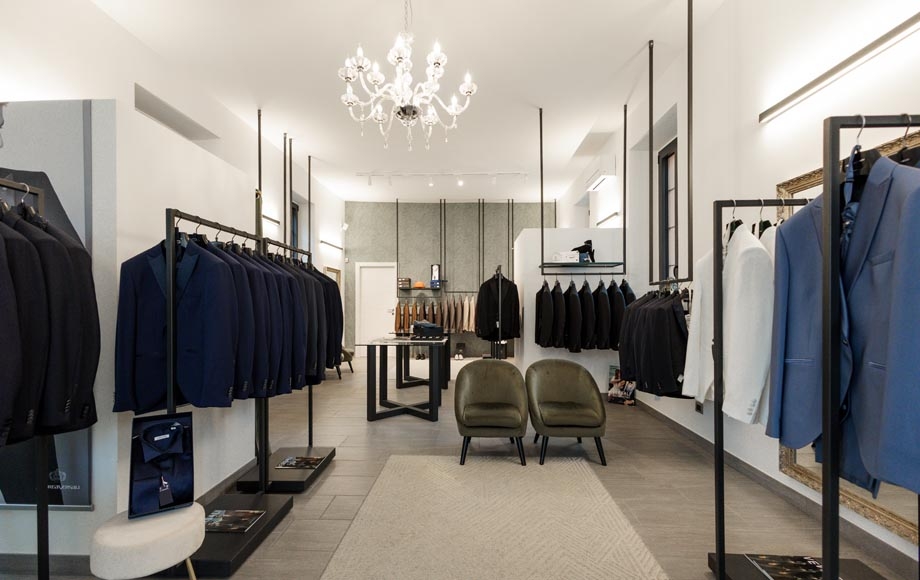 Showroom uomo con completi e lampadario