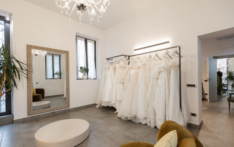 Sala sposa dell'atelier con abiti bianchi e specchio